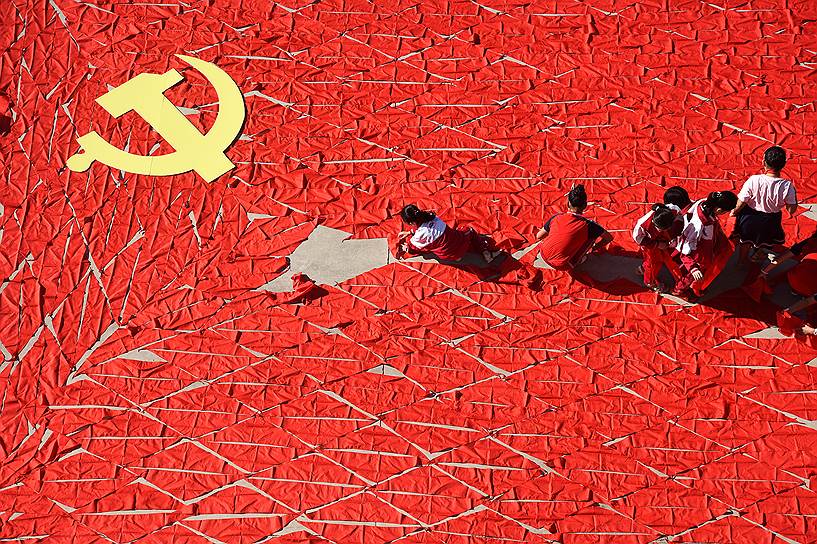 Шаньдун, Китай. Студенты складывают из красных галстуков флаг Коммунистической партии Китая