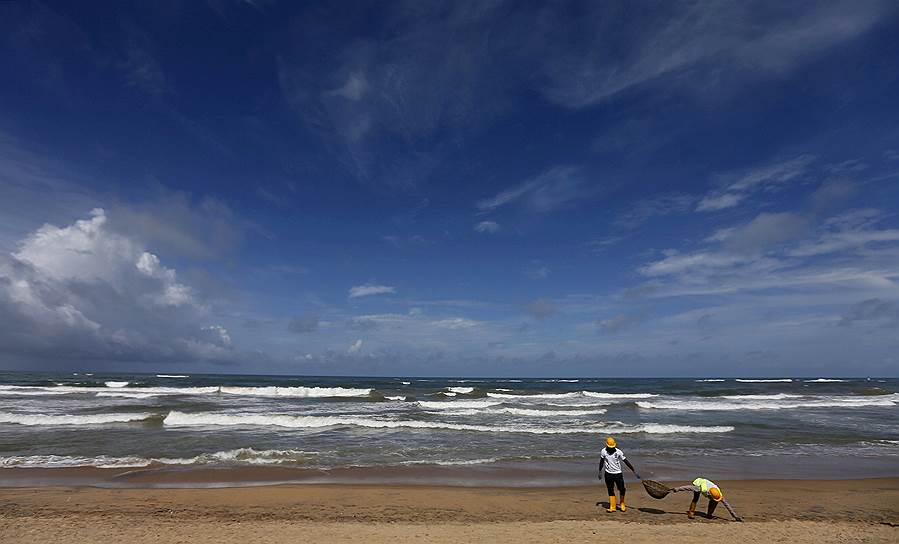 Маунт-Лавиния, Шри-Ланка. Рабочие собирают мусор на пляже перед Международным днем береговой охраны