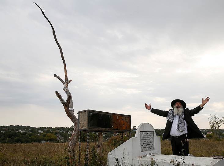 Умань, Черкасская область, Украина. Паломник молится у могилы на старом еврейском кладбище накануне праздника Рош Ха-Шана