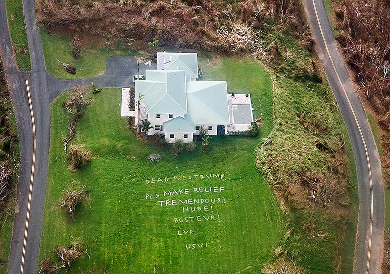 Санта-Крус, Виргинские острова, США. Из окна вертолета ВМФ видно, как один из домовладельцев просит президента Дональда Трампа о помощи 