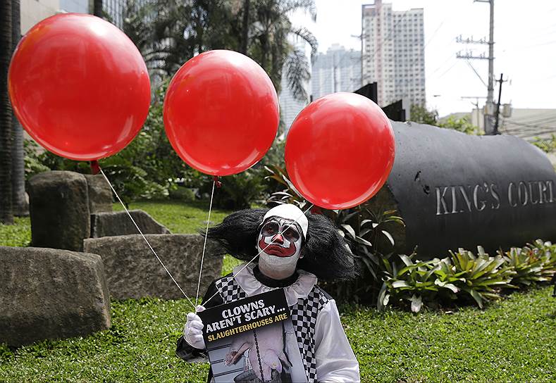 Манила, Филиппины. Приверженец вегетарианского стиля питания в костюме клоуна призывает отказаться от мяса