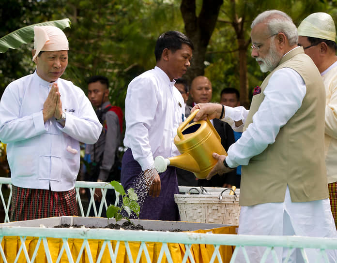 Премьер-министр Индии Нарендра Моди (справа) поливает посаженное баньяновое дерево во время посещения Пагоды Шведагон в Мьянме в сентябре 2017 года 