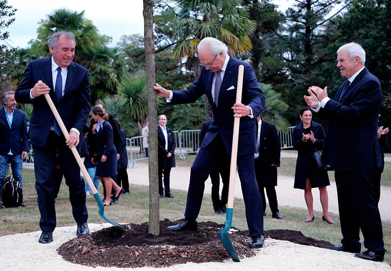 Король Швеции Карл XVI Густав (в центре) и мэр французского города По Франсуа Байру во время посадки дерева в октябре 2018 года
