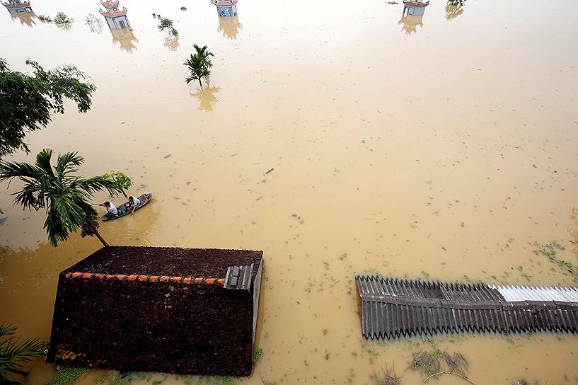 Ханой, Вьетнам. Местные жители плывут на лодке после паводков, вызванных тропическими ливнями 