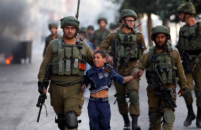 Хеврон, Западный берег реки Иордан. Израильские военные задержали палестинского мальчика  во время столкновений в городе