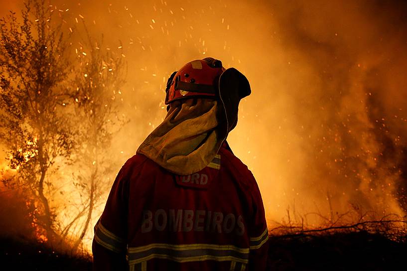 Лозан, Португалия. Пожарный борется с огнем 
