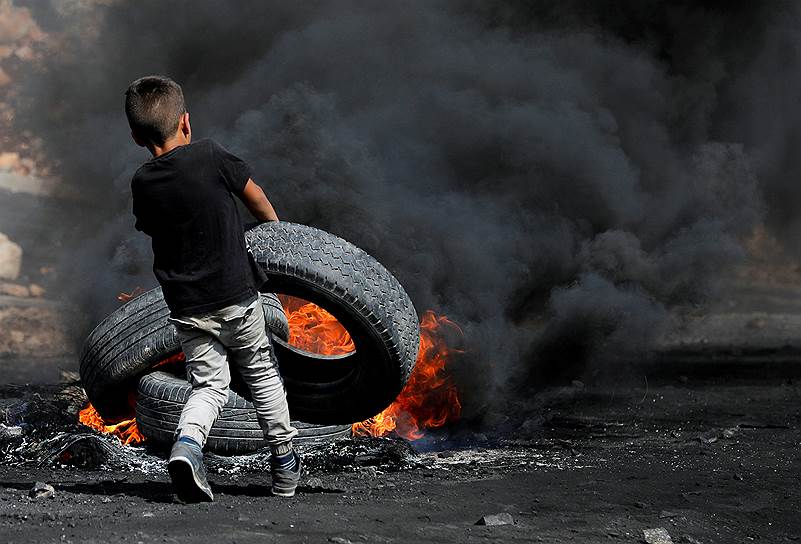 Кофр Квадом, Западный берег реки Иордан. Палестинский мальчик несет шину в огонь во время столкновений с израильскими военными