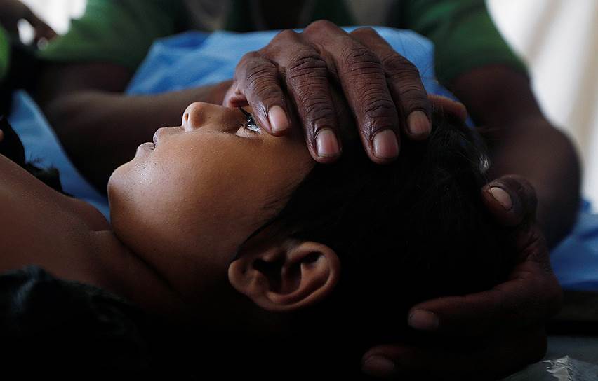 Кокс-Базар, Бангладеш. 35-летний беженец-рохинджа держит на руках тело дочери, погибшей в результате крушения судна с беженцами