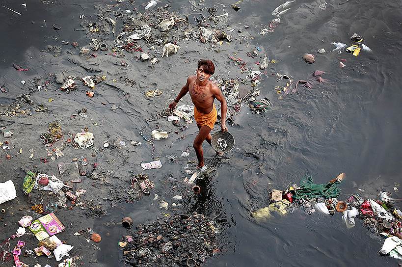 Нью-Дели, Индия.  Мужчина собирает мусор вблизи реки Джамна 
