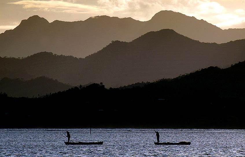 Сува, Фиджи. Местные жители ловят рыбу, стоя на лодках