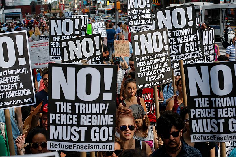 Нью-Йорк. Активисты несут баннеры «Нет! Режим Трампа / Пенса должен пасть!», протестуя против марша националистов 