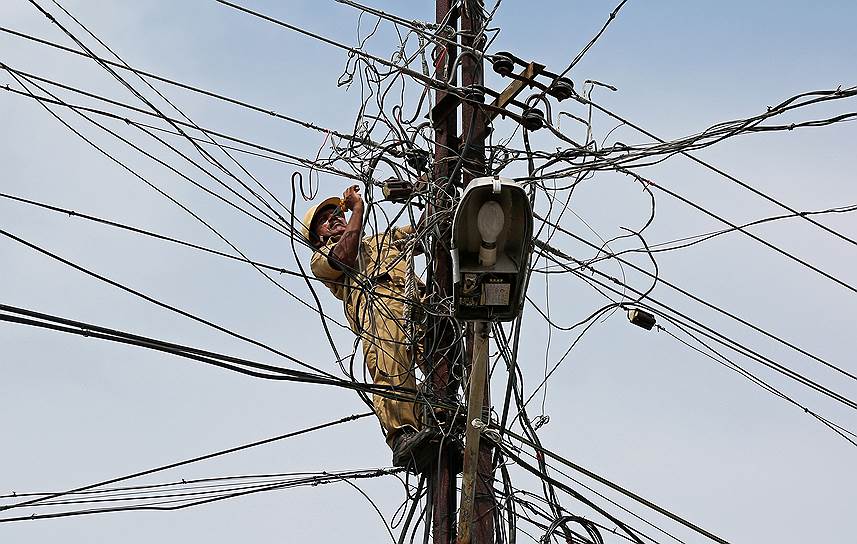 Кочи, Индия. Рабочий ремонтирует линию электропередачи