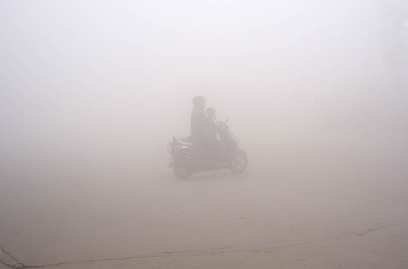 Большая Нойда, Индия. Женщина везет ребенка в школу на скутере сквозь смог