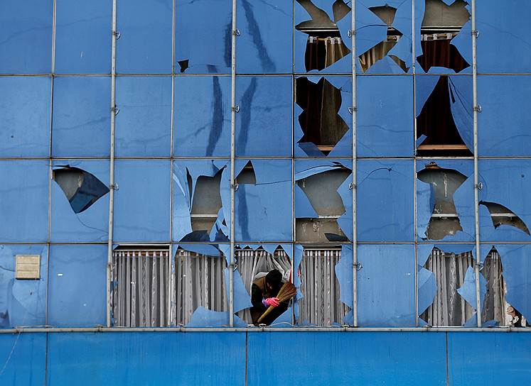 Кабул, Афганистан. Мужчина убирает битое стекло после взрыва смертника