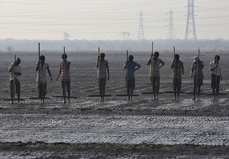 Мумбаи, Индия. Рабочие выравнивают соль