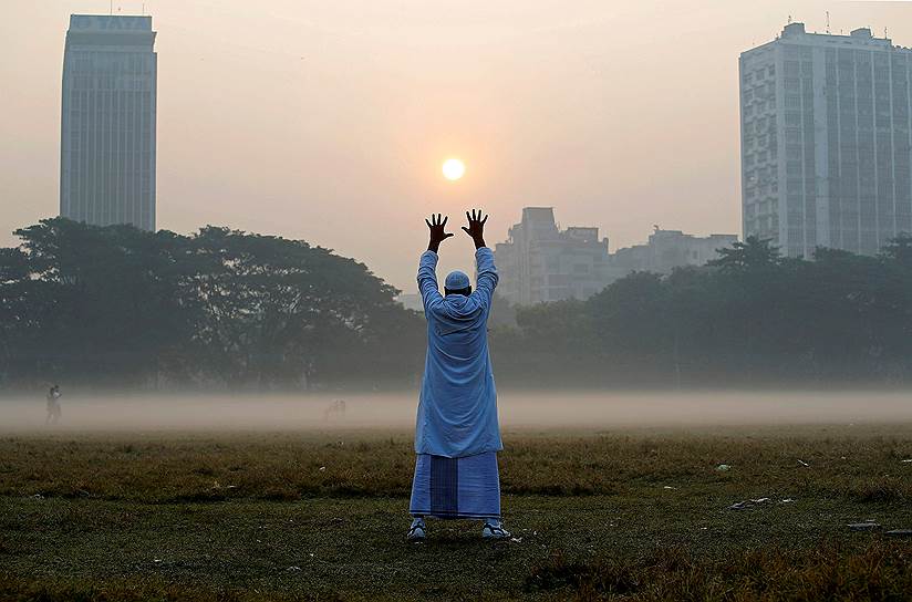Калькутта, Индия. Местный житель делает зарядку утром в парке