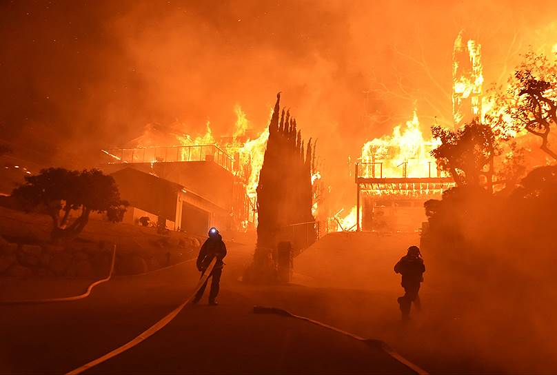 Округ Вентура, Калифорния, США. Пожарные борются с огнем, перекинувшимся с деревьев на дома