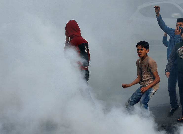 Протестующие в Газе палестинцы распыляют слезоточивый газ