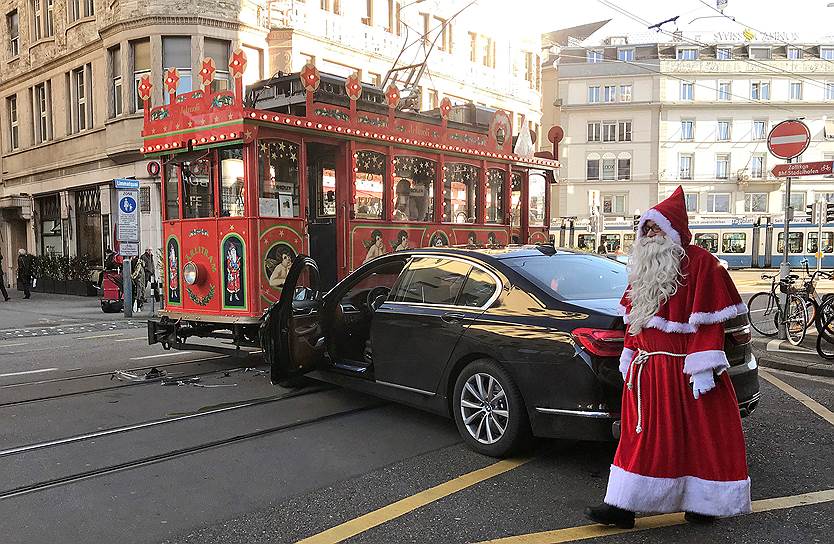 Цюрих, Швейцария. Водитель трамвая в костюме Санта-Клауса осматривает повреждения после столкновения с машиной
