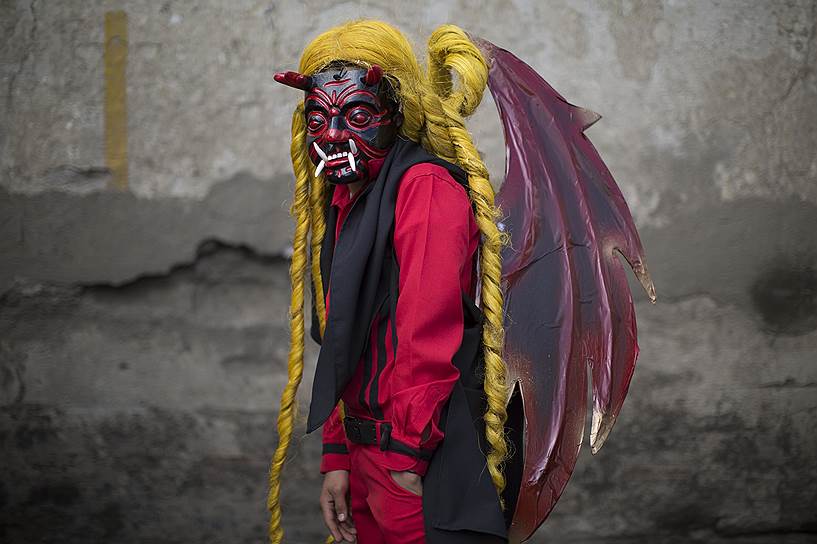 Сьюдад-Вьеха, Гватемала. 14-летний местный житель нарядился в костюм дьявола на церемонии, символизирующей борьбу сил зла и добра, во время торжественных мероприятий в честь непорочного зачатия Девы Марии