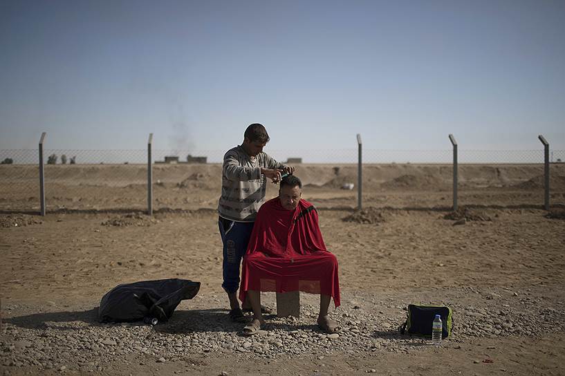 Мужчина стрижется в лагере к югу от Мосула
