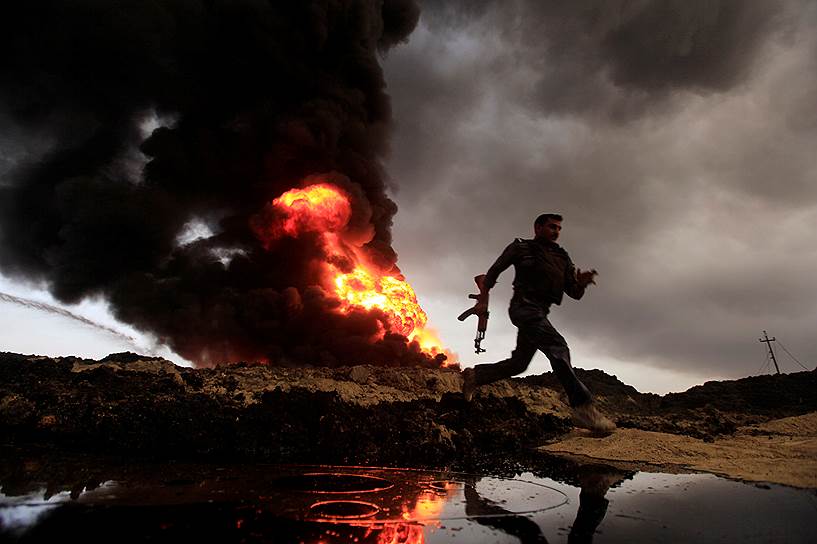 Горящие нефтяные скважины в Кайяре , оставленные боевиками ИГ