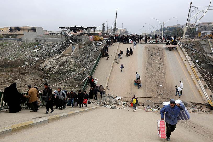 Мирные жители переходят разрушенный мост в мутафазе Мутанна
