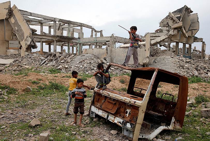 Иракские дети играют на руинах к югу от Мосула