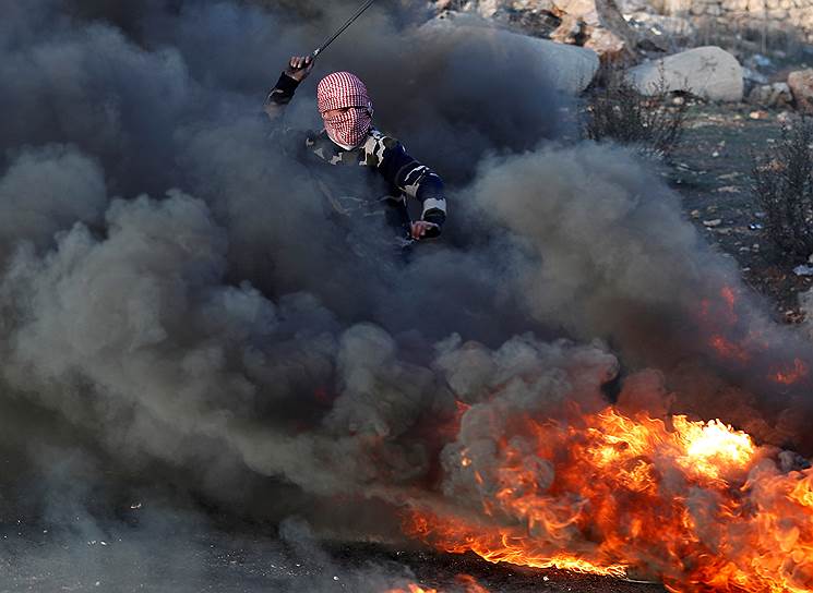 Бейт-Эль, Западный берег реки Иордан, Израиль. Палестинец бросает камень в израильских силовиков