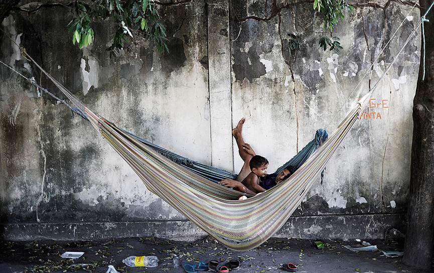 Боа-Виста, Бразилия. Семья венесуэльских беженцев отдыхает в гамаке