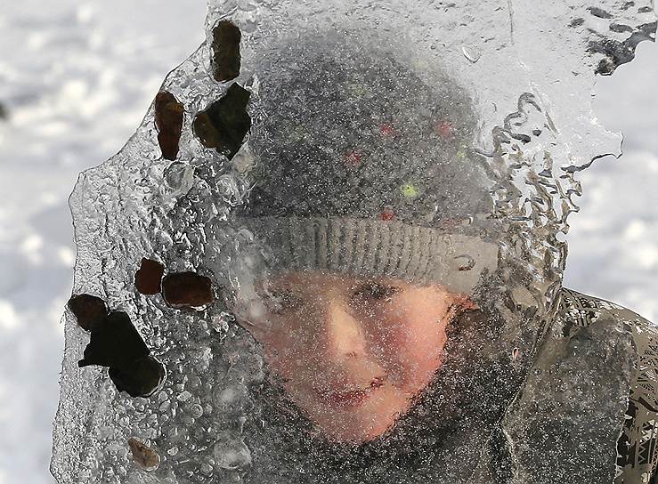 Дивногорск, Россия. Мальчик играет со льдом на берегу Енисея