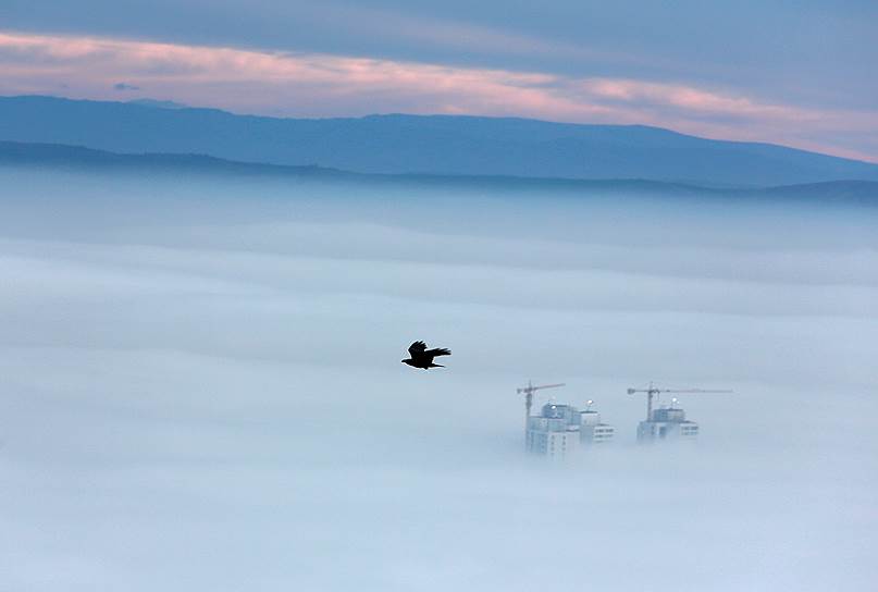 Скопье, Македония. В тумане над столицей видны только верхушки некоторых зданий