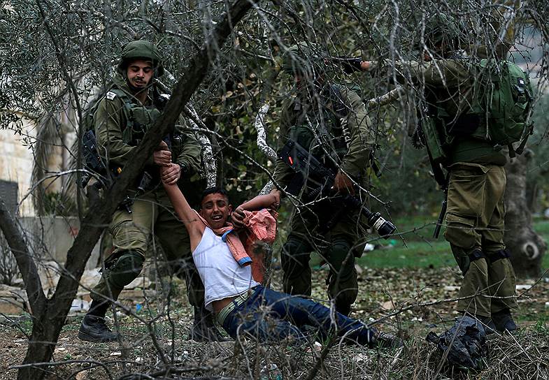 Наблус, Западный берег реки Иордан. Израильский солдат задерживает палестинского протестующего 