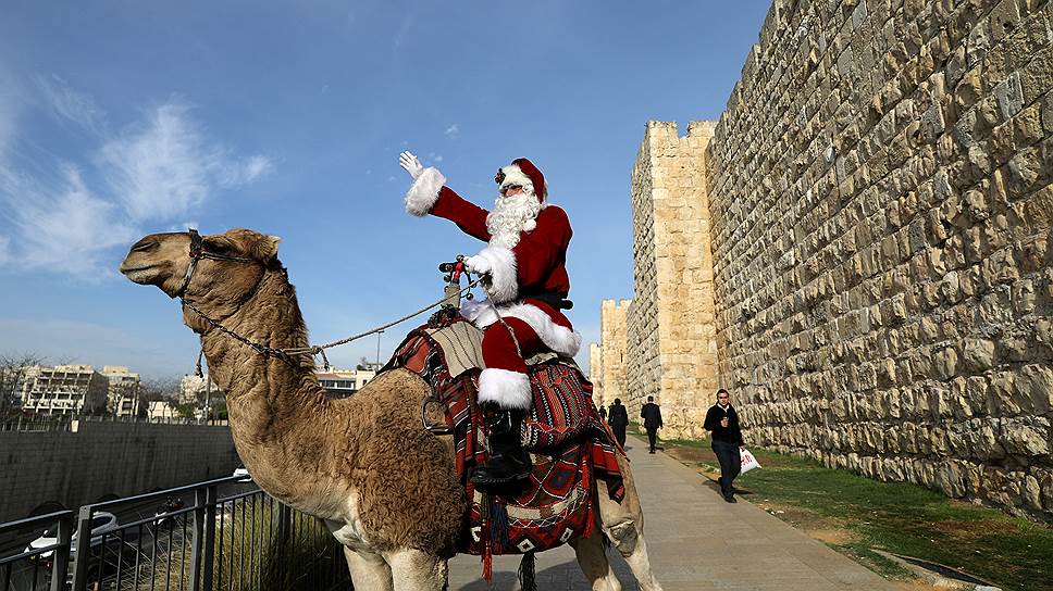 Иерусалим, Израиль. Мужчина в костюме Санта-Клауса на ежегодной раздаче новогодних елок от муниципалитета