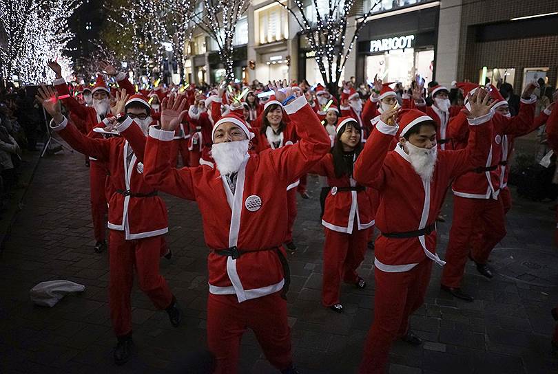 Токио, Япония. Шествие местных работников в костюмах Санта-Клауса 