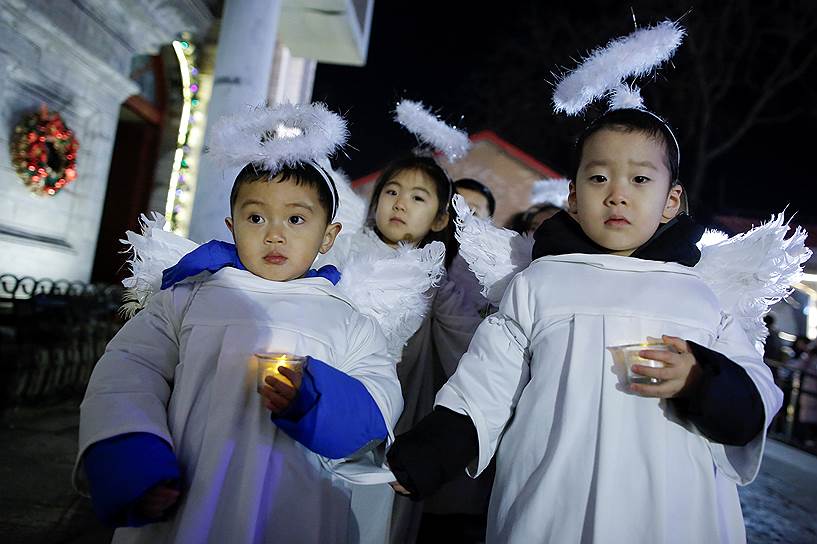 Пекин, Китай. Дети в костюмах ангелов участвуют в рождественской мессе в соборе Непорочного зачатия
