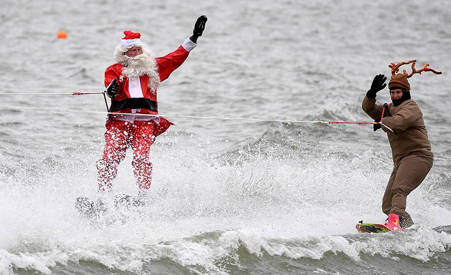 Александрия, штат Виргиния (США). Санта-Клаус и один из его оленей катаются на водных лыжах