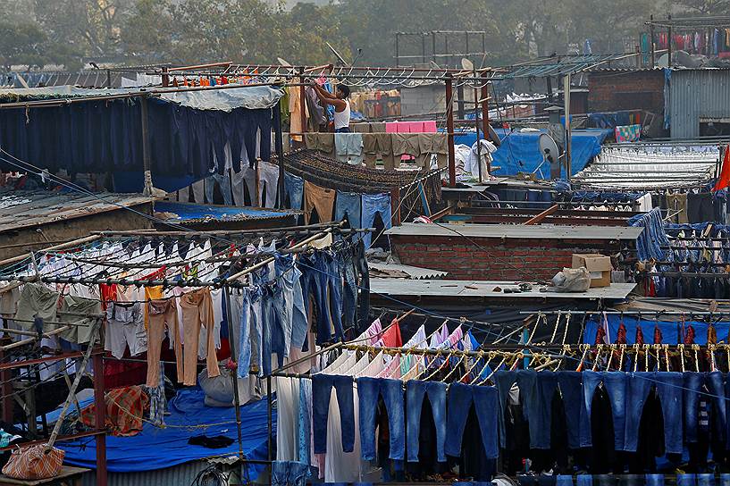 Мумбаи, Индия. Работник прачечной развешивает одежду