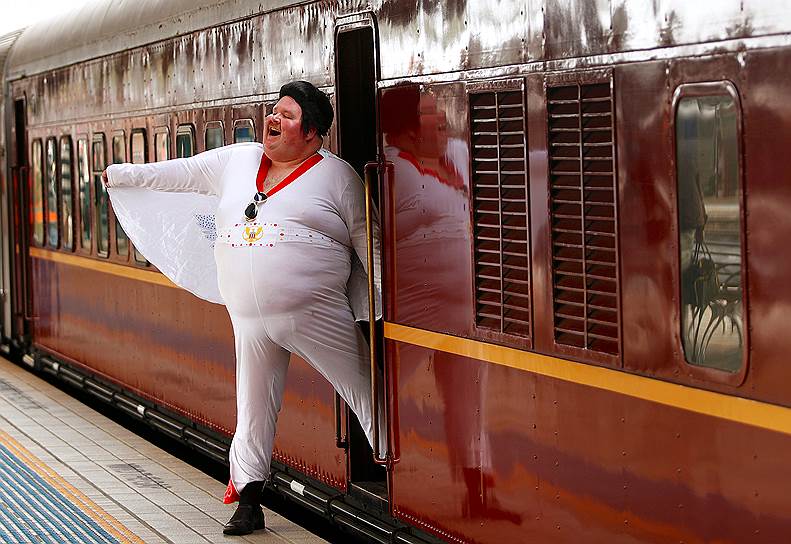 Сидней, Австралия. Двойник Элвиса Пресли позирует у поезда, следующего в Новый Южный Уэльс, где проходит ежегодный фестиваль в честь музыканта