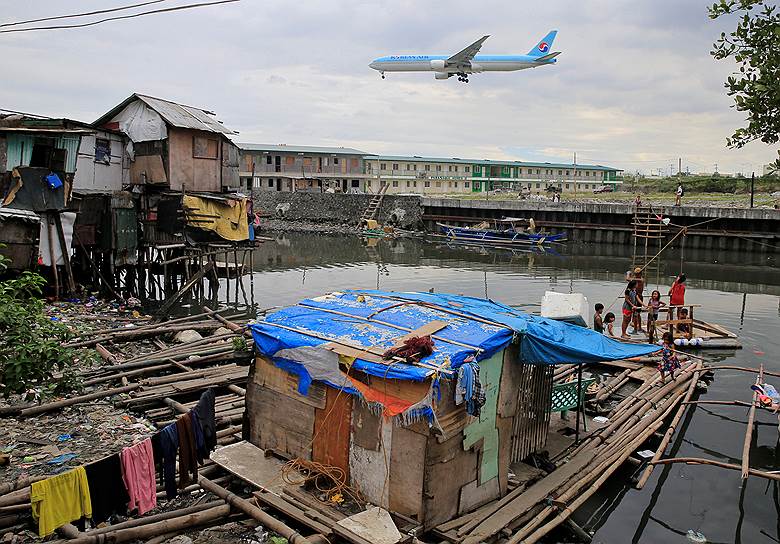 Паранак, Филиппины. Самолет Korean Air пролетает над столичными трущобами