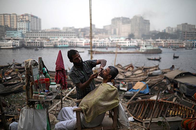 Дакка, Бангладеш. Уличный парикмахер за работой на берегу реки Буриганги