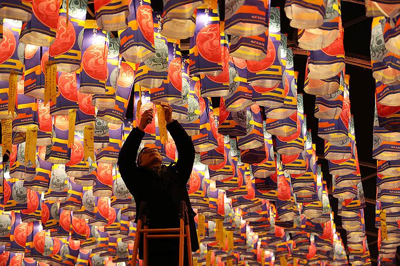 Сиань, Китай. Местный житель привязывает ленточку со своим желанием к фонарику в преддверии Китайского нового года
