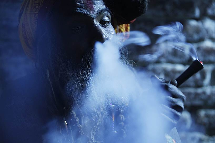 Катманду, Непал. Верующий курит марихуану в храмовом комплексе Пашупатинатх в канун праздника бога Шивы