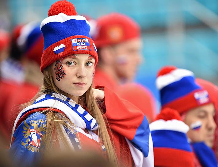 Болельщица в шапке «Россия в моем сердце» наблюдает за ходом матча по хоккею между Россией и Словакией 