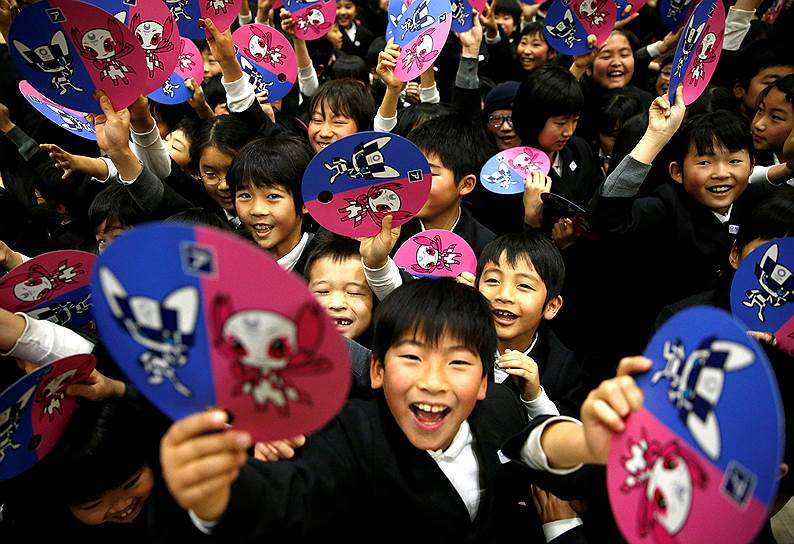 Токио, Япония. Школьники держат в руках бумажки с талисманами Олимпиады 2020 года, которая пройдет в японской столице
