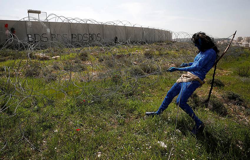 Билин, Западный берег реки Иордан. Демонстрант убирает колючую проволоку на границе с Израилем