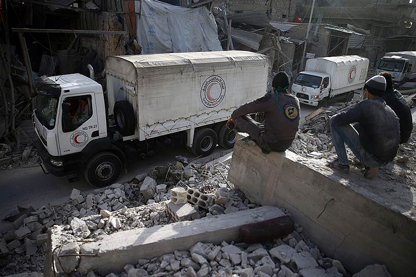 Дума, Сирия. Местные жители наблюдают за колонной гуманитарной помощи, которую доставляет организация  Красный полумесяц  
