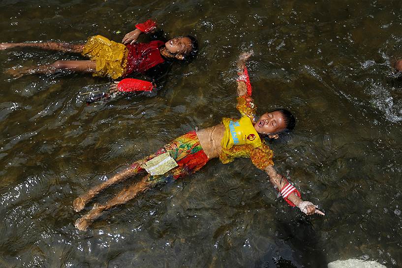 Джакарта, Индонезия. Дети плавают в порту во время прилива 