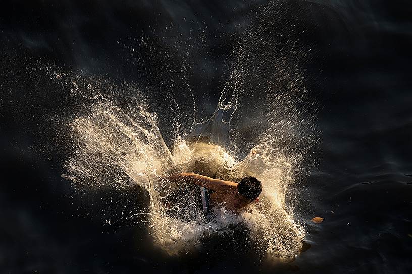 Бангкок, Таиланд. Мальчик купается в загрязненном водоеме
