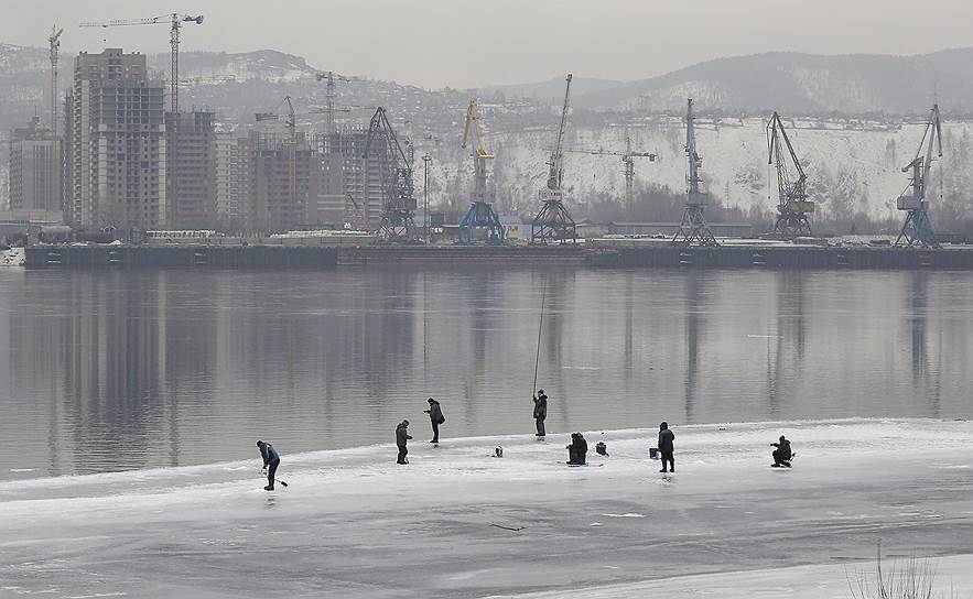 Красноярск, Россия. Местные жители рыбачат на покрытой льдом реке Енисей